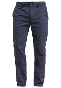 Chinos de algodón azul marino con un acabado mate, diseño de pierna recta, bolsillos frontales y un sutil logo bordado por encima de la cinturilla.