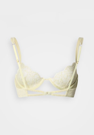 Κίτρινο δαντελένιο σουτιέν με διαφανείς cups, ρυθμιζόμενους ιμάντες και κούμπωμα με αγκράφα στο πίσω μέρος. Απαλό ύφασμα με διακοσμητική δαντέλα σε κυματοειδές σχέδιο.