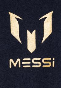 Tessuto blu navy con un logo dorato e lettere stilizzate "MESSI" con forme geometriche sopra. Texture liscia, design di stampa chiaro.