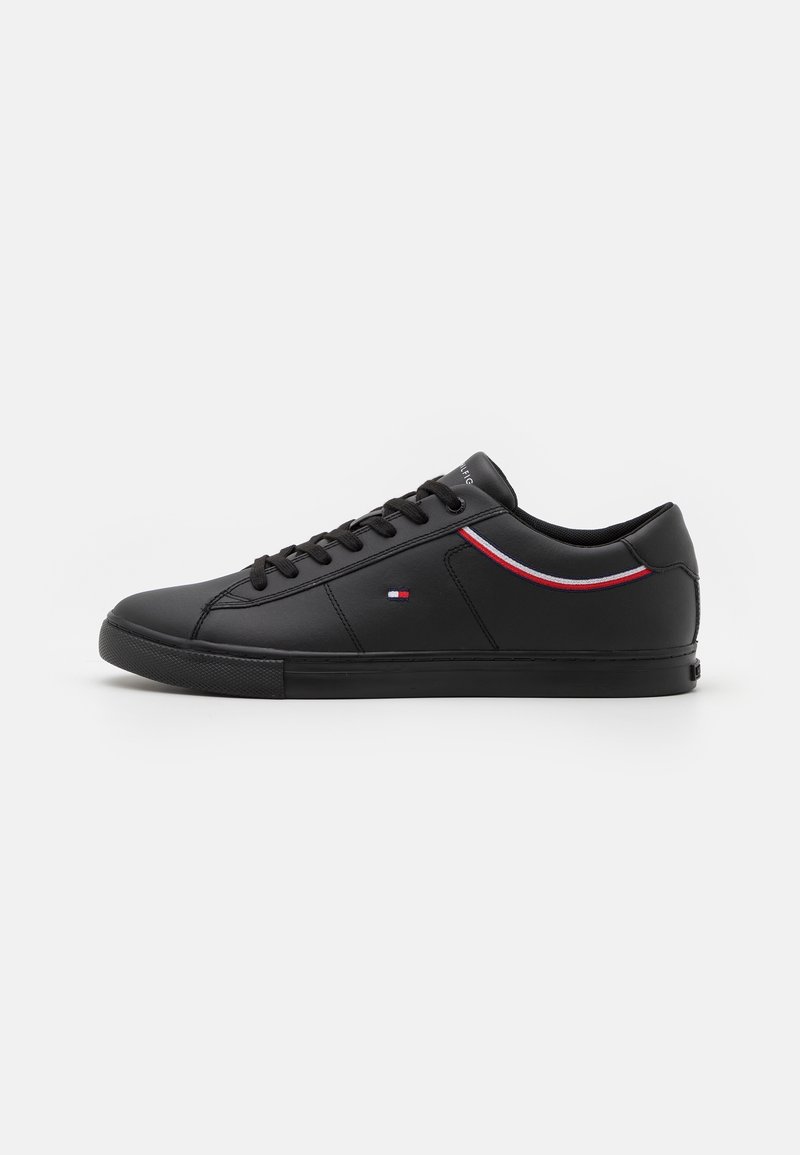 Schwarze synthetische Sneaker mit flachen Sohlen, runder Zehenpartie und Schnürverschluss. Mit buntem Streifenmuster und Logo-Applikation an der Seite.