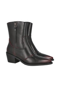Botas de cowboy de cuero negro con punta afilada, costuras rojas y cremallera lateral; tacón grueso y patrón decorativo cosido en la punta.