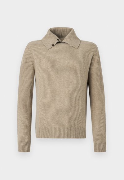 Μπεζ πλεκτό πουλόβερ με ριμπ ύφανση, γιακά που διπλώνει και δύο διακοσμητικά κουμπιά στον γιακά. Μακριά μανίκια και εφαρμοστό τελείωμα.