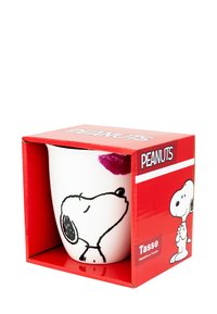 Tazza di ceramica bianca con disegni in linea neri di Snoopy, caratterizzata da un bacio rosa. È confezionata in una scatola rossa etichettata "PEANUTS."