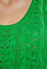Groene gebreide trui met een ronde halslijn, intrigerende bladerenpatronen en een textuur met kabeldesign door de gehele stof.