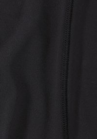 Schwarzer Stoff mit glatter Textur, der entlang der Kante eine sichtbare, vertikal verlaufende Naht aufweist. Keine Muster oder Hardware-Details vorhanden.