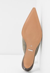 Semelle d’une chaussure plate beige à bout pointu montrant un motif de grip strié, taille 38, et étiquette de la marque près du talon.
