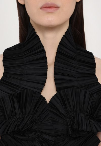 Black garment with a structured, pleated design featuring distinct ruffled accents around the neckline and body, highlighting texture and form.