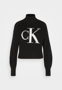 Maglione nero a collo alto corto realizzato in materiale a coste, con un grande logo bianco "ck" sul davanti. Maniche lunghe e aderenti completano il design.