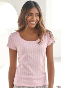 Pink short-sleeve shirt with a scooped neckline, featuring a textured pattern of vertical lines and small shapes, and scalloped edges.