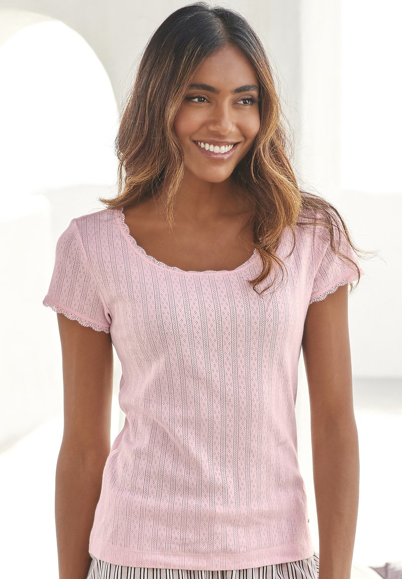 Pink short-sleeve shirt with a scooped neckline, featuring a textured pattern of vertical lines and small shapes, and scalloped edges.