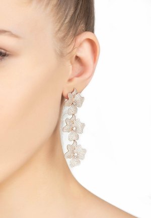 Gold-tone earrings featuring four interconnected floral designs, embellished with clear rhinestones, creating a textured and sparkling appearance.