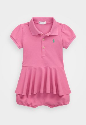 Ružičasta polo haljina s kratkim napučenim rukavima, plisiranim suknjom i elastičnom strukom. Ima mali zeleni logotip ponyja na prsima.
