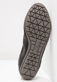 Black leather shoe with a rubber sole featuring a triangular tread pattern. Size 37 marked on the side with a smooth, curved edge.