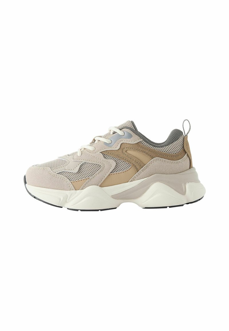 Lyse beige sneakers med ruskind og mesh-materialer, der har et tekstureret design, neutrale accenter og en tyk hvid sål med sorte detaljer.