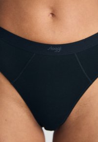 Zwarte Sloggi slip met een zachte tailleband, naadloze zijkanten en een minimalistisch ontwerp. Gemaakt van rekbaar materiaal voor comfort en flexibiliteit.