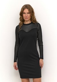 Črna obleka z dolgimi rokavi, ki ima prosojen zgornji del, ukrivljen izrez in oprijet silhueto. Gladka tekstura z elegantnim videzom.
