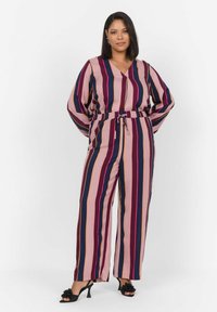 Combinaison rayée en rose, bleu marine et bordeaux. Dotée d'un décolleté en V, de manches longues et d'une taille élastique avec un lien. Tissu doux et léger.