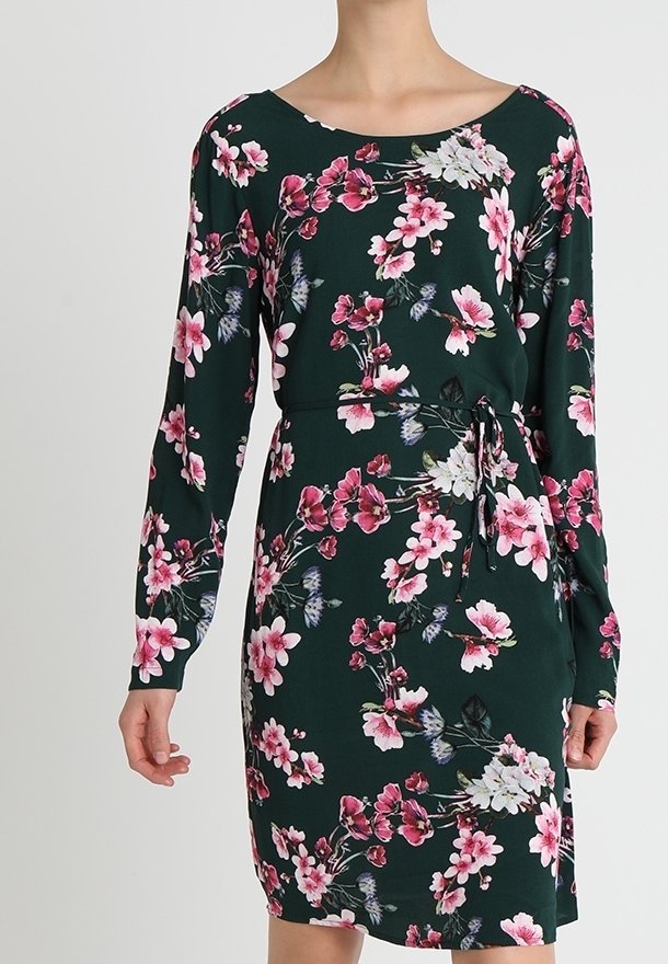 Bloemenjurk met lange mouwen, donkergroene basis, roze en witte bloemenpatroon, en een strikceintuur in de taille. Zachte stof, aansluitend ontwerp.