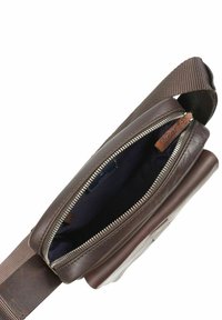 Braune Ledertasche mit einem Reißverschluss, Stoffgurt und einem dunklen Innenraum. Verfügt über eine glatte Textur und ein minimalistischem Design.
