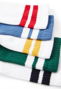 Cinco pares de calcetines a rayas en blanco, azul, rojo, verde y negro. Cada calcetín tiene rayas en contraste. El material parece acanalado y texturizado.