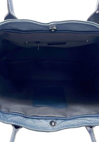 Blauwe leren tote bag met een gestructureerde afwerking, voorzien van een ritssluiting en een binnenzak. De voering is in een donkerdere tint blauw.