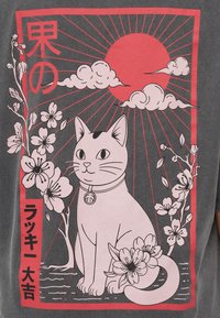 Στυλιζαρισμένη γάτα με περιλαίμιο κάθεται ανάμεσα σε άνθη κερασιάς υπό έναν κόκκινο ήλιο και σύννεφα, περικλεισμένη από ιαπωνικούς χαρακτήρες και λουλουδένια σχέδια.