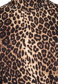 Gornja majica s uzorkom leopard-štampe s visokim ovratnikom. Sadrži mekan, teksturiran materijal u bež i smeškastim nijansama, prikazujući smeli, nepravilni uzorak.
