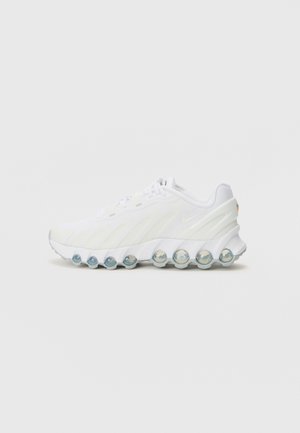 Baskets de sport blanches avec un dessus texturé, dotées d'une semelle à bulle transparente et d'un logo discret sur le talon. Matériau lisse et design épuré.