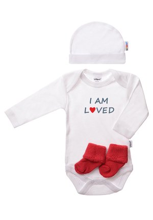 White long-sleeve onesie with "I AM LOVED" text, paired with red fuzzy booties and a matching white hat. Soft cotton material.