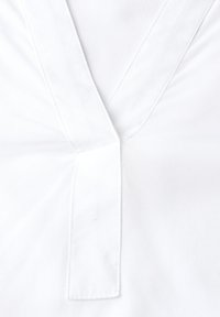 Camicia bianca in cotone con un design a V e una patta, impreziosita da dettagli di cucitura sottili. Texture liscia con un aspetto leggero.