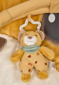 Soft, plush toy bear with a beige body, patterned with colorful heart shapes. Features a teal scarf and a hanging star-shaped clip.