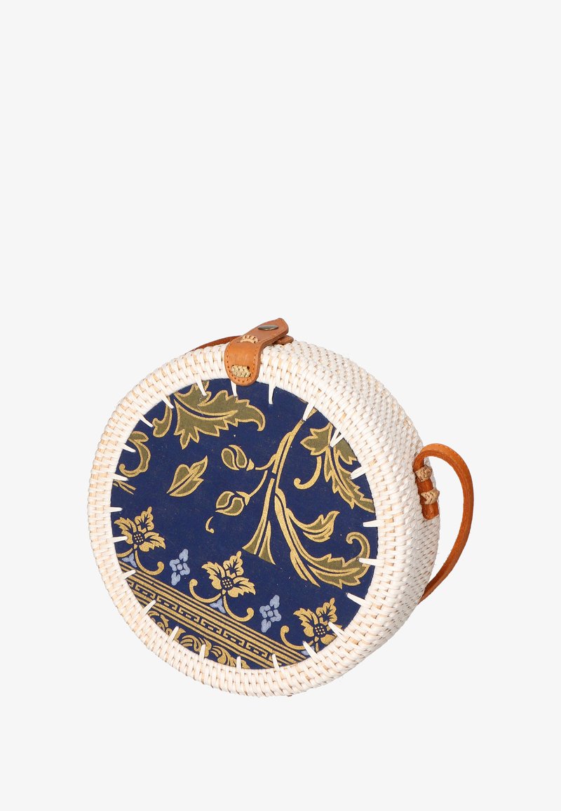 Borsa rotonda intrecciata con rattan bianco, tessuto blu marina con motivi floreali dorati e una tracolla e dettagli in cuoio marrone.