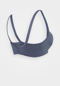 Temno modra športna modrc s gladko teksturo, širokimi naramnicami in zaponko. Ima oblikovan kroj in subtilno šivano podrobnost.