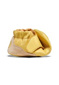 Chaussure pour bébé en cuir jaune doux avec semelle flexible, couture latérale et élastique à la cheville, présentée sur fond blanc.