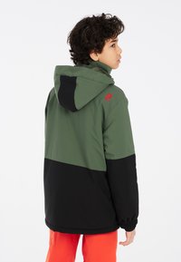 Giacca verde e nera con cappuccio, dotata di polsini elasticizzati e un logo sulla spalla. Tessuto morbido al tatto, design casual.