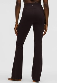 Zwarte hoge taille flared leggings van rekbaar materiaal, met een zachte textuur en een strakke pasvorm.