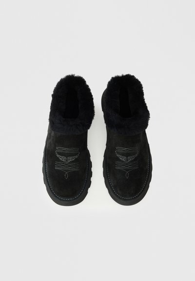 Czarne zamszowe botki za kostkę z futrzanym wykończeniem, teksturowana powierzchnia, gumowa podeszwa oraz dekoracyjne przeszycia na cholewce i związaniach.