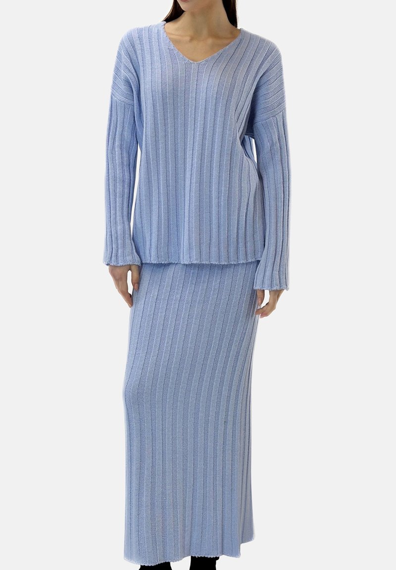 Ensemble assorti tricoté bleu clair composé d'un haut à manches longues avec col en V et d'une jupe maxi assortie, tous deux présentant une texture côtelée verticale.