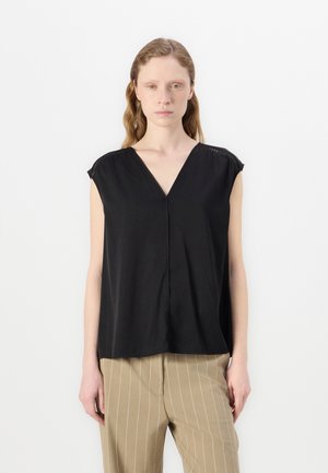 Top nero a maniche corte con scollo a V e vestibilità rilassata. Realizzato in tessuto morbido, presenta cuciture discrete lungo le spalle.