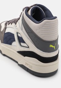 High-Top-Sneaker mit grauen, marineblauen und cremefarbenen Elementen. Verfügt über strukturiertes Wildleder und glattes Leder. Puma-Logo in Limettengrün an der Ferse.