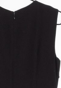 Mustaton ilmanhiha dressi, jossa on korkea kaulus, sileä pinta ja piilotettu vetoketju takana. Ominaisuudet ovat selkeät linjat ja minimalistinen muotoilu.