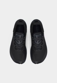 Ζεύγος μαύρα αθλητικά παπούτσια για τρέξιμο σε μονοπάτια με κορδόνια, από πάνω σε λευκό φόντο.