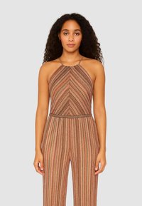 Tuta a righe con design a collo halter, caratterizzata da linee verticali in tonalità terrose di marrone, arancione e verde. Tessuto testurizzato con vita aderente.