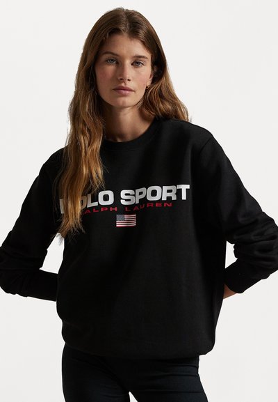 Sweatshirt negru cu textul "POLO SPORT" și "RALPH LAUREN" în alb și roșu. Include un design cu steagul american. Are mâneci lungi și guler rotund.