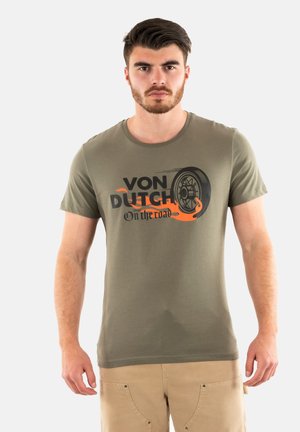 T-shirt en coton vert olive avec un graphisme noir et orange portant "VON DUTCH" et un motif de pneu. Manches courtes et col rond.