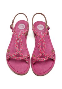 Sandalias rosas con correas trenzadas, adornadas con pequeños acentos plateados, que presentan una textura suave de ante y un diseño de punta abierta.