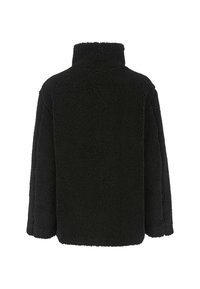 Mustan korkeakauluksinen sherpa-fleece-takki näkyy takaa, jossa on pitkät hihat ja teksturoitu, pörröinen pinta.
