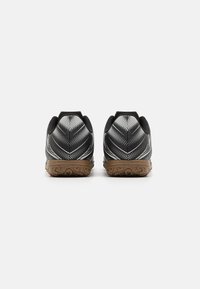 Zapatillas deportivas negras con un diseño texturizado, que cuentan con una suela de goma oscura y una parte superior ligera y con patrón que tiene detalles reflectantes.