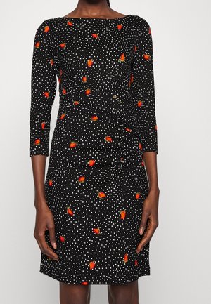 Robe noire cintrée à pois blancs et petits motifs de roses rouges, avec des manches trois-quarts et un détail froncé à l'avant.