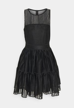 Black sleeveless dress featuring a sheer, vertically striped bodice and a tiered, pleated skirt. Simple round neckline and waistband.